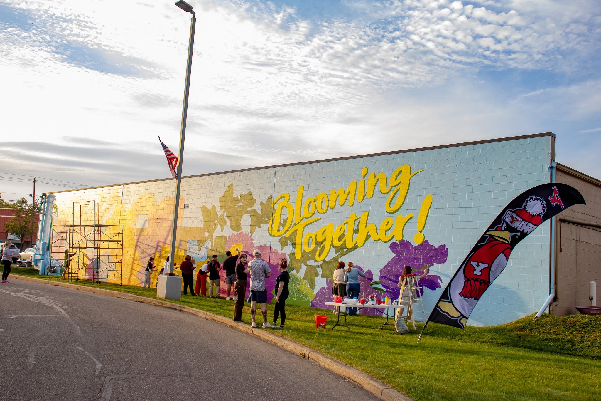 Community members, YSU faculty and students putting the finishing touches on a mural at Blooming Crazy Flowers and Gifts