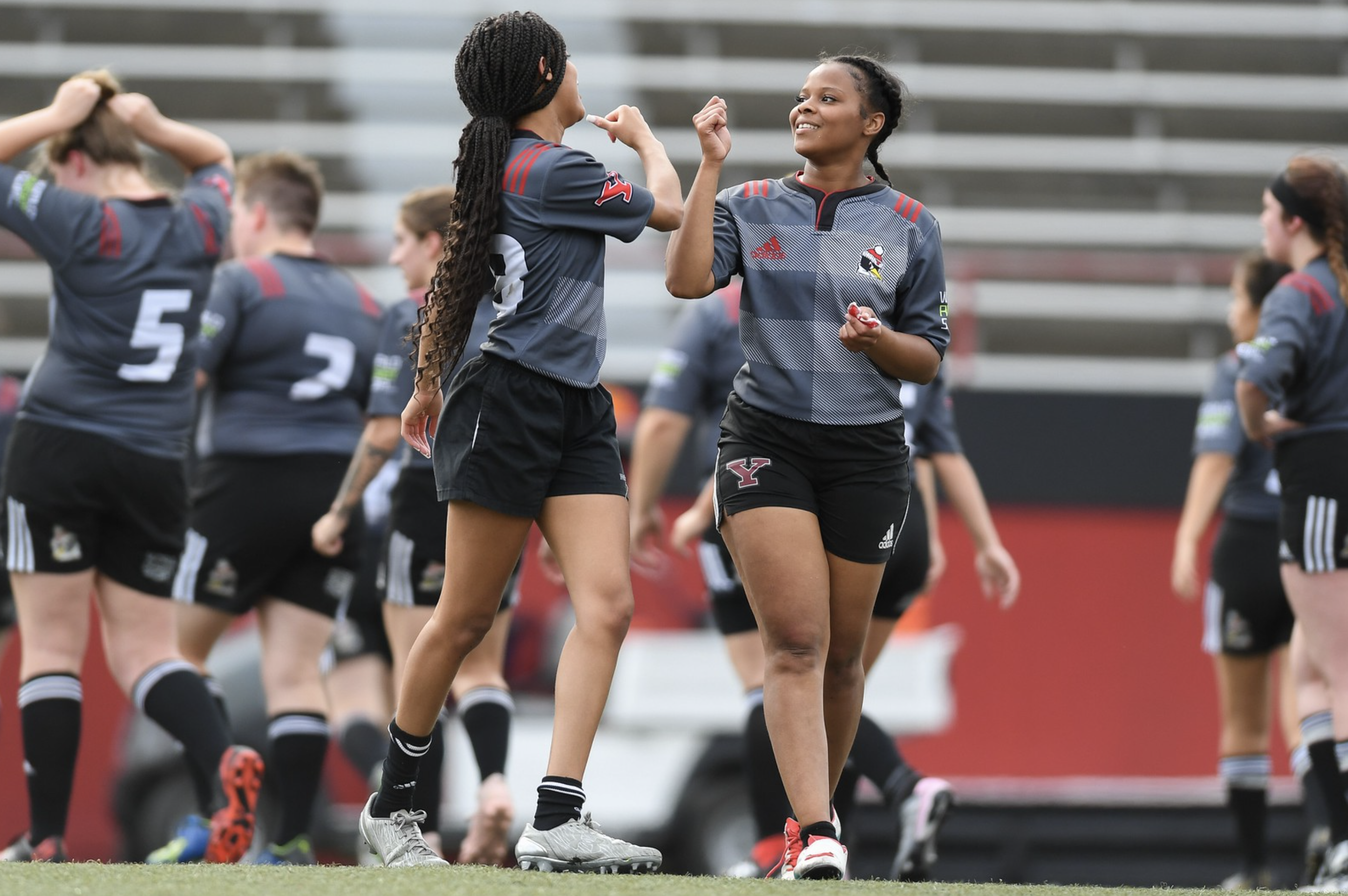 two rugby players fist bump on the football field