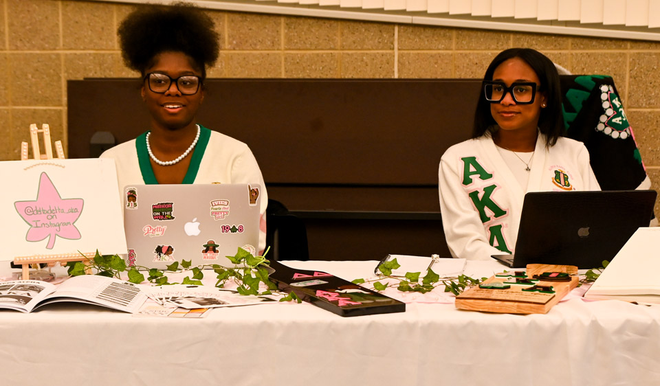 2 Alpha Kappa Alpha girls at table