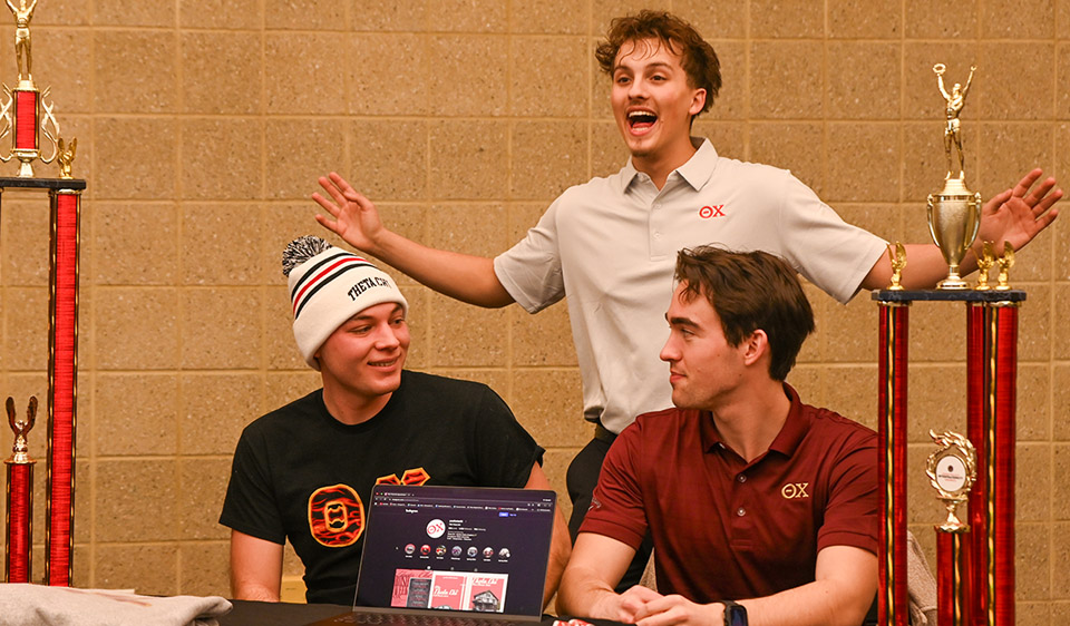 3 Theta Chi members with trophies