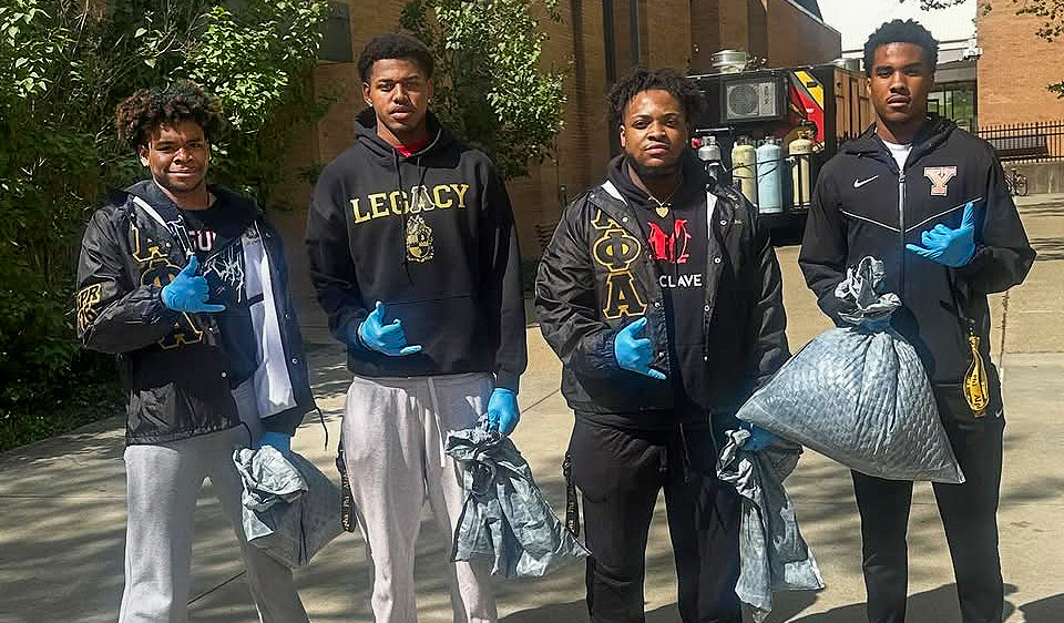 4 Alpha Phi Alpha members cleaning up campus