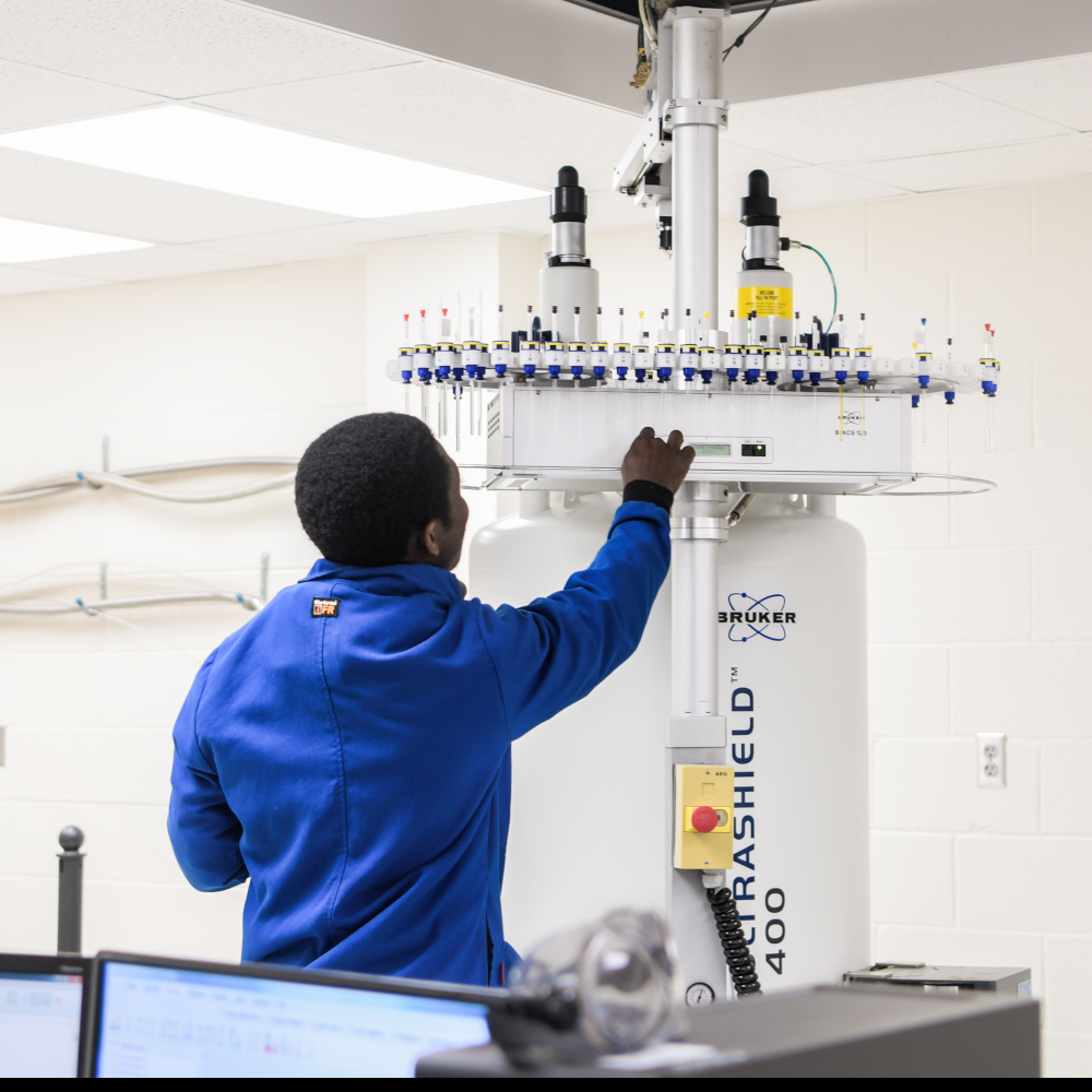 student in lab environment operating machinery