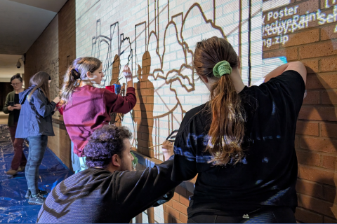 Students tracing the mural on Kilcawley Center