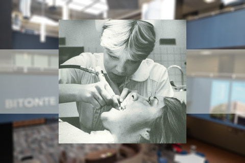 Black and white image of a student dental hygienist cleaning teeth