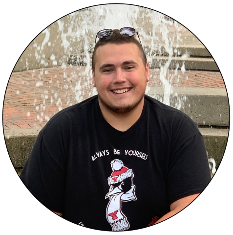 Mario Campalong sits on the side of the fountain at Youngstown State University