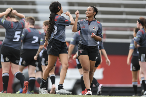 two rugby players fist bump on the football field