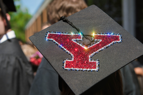 A graduation cap decorated with red rhinestones in the shape of Y.