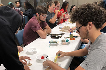 Students admiring their artwork at the Block Y Painting Party
