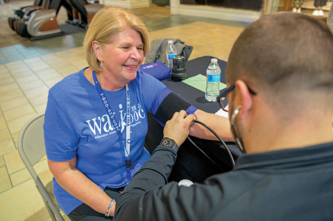 Student taking a walker's blood pressure