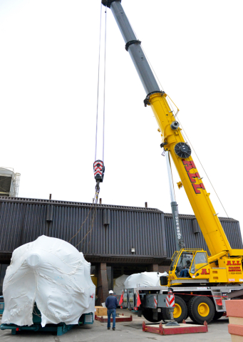 Workers prepare to move a boiler into the utility building at YSU as part of the installation of the university