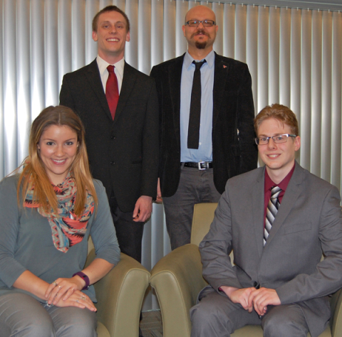 From the left, seated are students Abigail Kunce and Christopher Morse; standing, student Chad Limbruner and Emre Ulusoy, assistant professor of Marketing.
