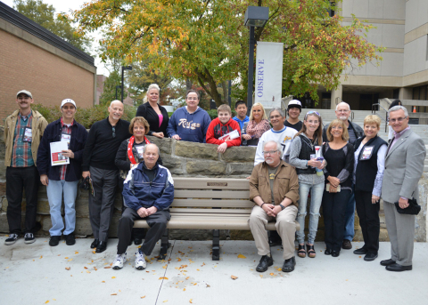 YSU President Jim Tressel, far right, poses with the Papagna family at a bench outside the YSU Ward Beecher Planetarium in honor of the late William T. Papagna. Through a family trust, Papagna designated the funds to benefit the planetarium and to purchase a memorial bench in support of the Campus Beautification Initiative. 