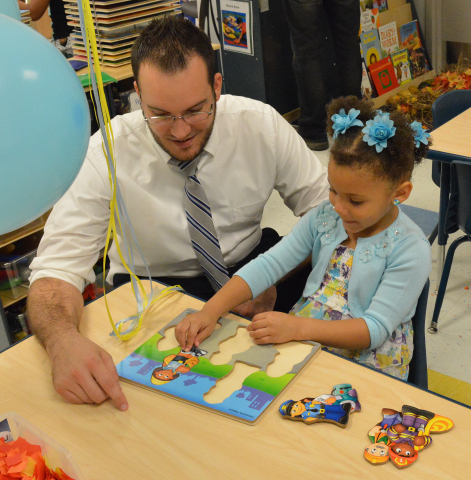 David Tharp, human resources manager at Alta Head Start, works on a puzzle with a child at the new H