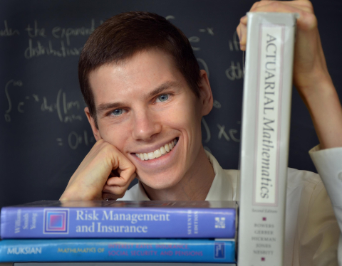 Man posing with mathematics books 